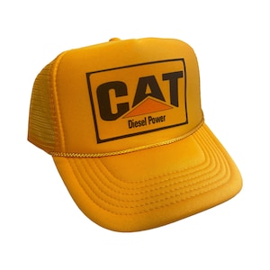 May include: Yellow trucker hat with a black and orange CAT logo and the text "Diesel Power".