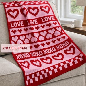 May include: A red and pink crocheted blanket with the words "LOVE" and "XOXO" interspersed with heart patterns. The blanket is draped over a gray sofa. The blanket's design includes a checkered border.