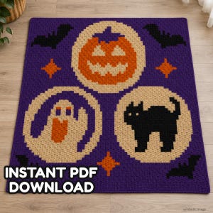 May include: A rectangular purple crochet blanket featuring three circular beige panels. The top panel displays an orange jack-o'-lantern, the bottom left a white ghost, and the bottom right a black cat. Black bats and orange stars accent the purple background.