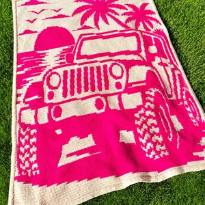 May include: A rectangular crochet blanket featuring a vibrant hot pink and cream color scheme. The design depicts a front-facing off-road vehicle parked on a beach with palm trees, a large sun, and birds in the sky, all rendered in a pixelated style.