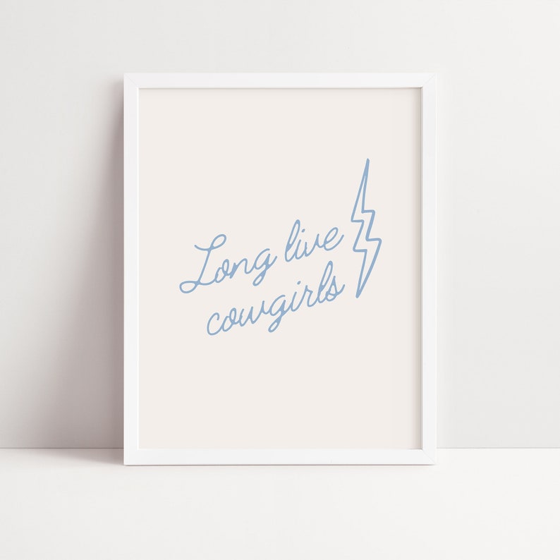 May include: A white framed print with a light blue lightning bolt and the text "Long live cowgirls" in a cursive font.