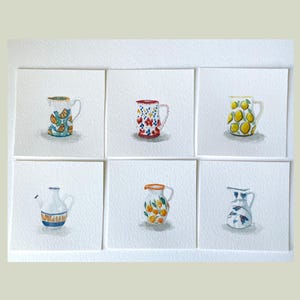 May include: Six watercolour paintings of small jugs, each on a white square. The jugs feature various designs, including citrus fruits, floral patterns, and geometric shapes. The colour palette includes blues, oranges, yellows, and reds.