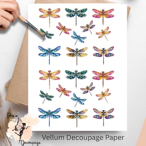 May include: Vellum decoupage paper featuring colorful dragonfly designs. The dragonflies are in various colors, including blue, pink, yellow, and green. The paper is on a white background with a brown envelope and a paintbrush.