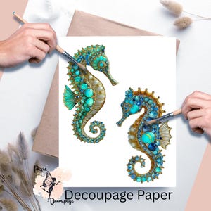 May include: Two seahorse designs on white paper, embellished with turquoise and gold accents. The seahorses are being painted with a paintbrush. The words "Pixie Decoupage" and "Decoupage Paper" are also visible.