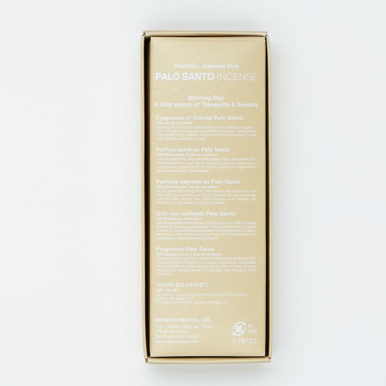 May include: A gold box with a white label that reads "Palo Santo Incense" and "Morning Star". The label also includes the text "A daily source of Tranquility & Serenity" and "Fragrance of Sacred Palo Santo" in English, French, Spanish, German, Italian, and Japanese.