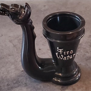 May include: Black plastic dragon-shaped pipe with a round opening at the top and the words "Fire Water" inscribed on the side.