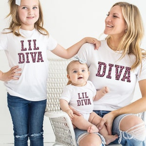 May include: Three white t-shirts with pink leopard print text. The shirts say "Lil Diva", "Lil Diva", and "Diva".