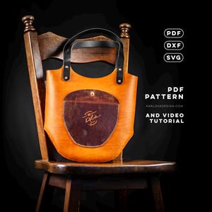 Peut inclure: Un sac cabas en cuir beige avec des anses en cuir noir et une poche avant en cuir marron foncé. Le texte PDF, DXF, SVG, PDF PATTERN, KARLOVADESIGN.COM, AND VIDEO TUTORIAL est visible. Le sac présente une base incurvée et des rivets.