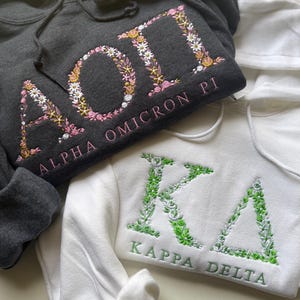 Sudadera con capucha bordada con letras griegas y flores personalizable. Ideal para hermandades, fraternidades, vida griega, vida universitaria y regalos para grandes y pequeños.