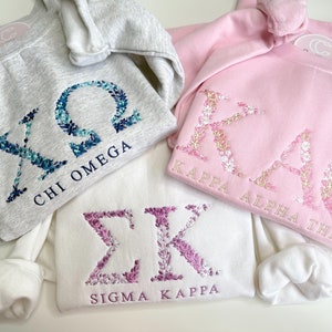 Sudadera con bordado floral y letras griegas personalizable. Ideal para hermandades, fraternidades, vida griega, vida universitaria y regalos para grandes y pequeños.