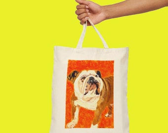 May include: A white canvas tote bag with a brown and white bulldog illustration on an orange background. The bulldog is looking to the left and has a wrinkled face.