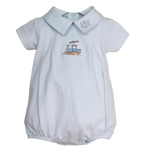 May include: Light blue baby romper with a Peter Pan collar and short sleeves. The romper features an embroidered train design on the front and monogram initials on the collar. The bottom has a bubble shape.