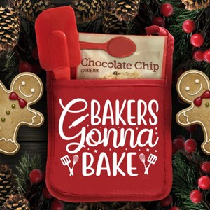 May include: Red oven mitt with a white design that says "Bakers Gonna Bake" with a rolling pin, whisk, and spatula. The oven mitt has a pocket on the front that holds a red spatula and a bag of chocolate chip cookie mix.