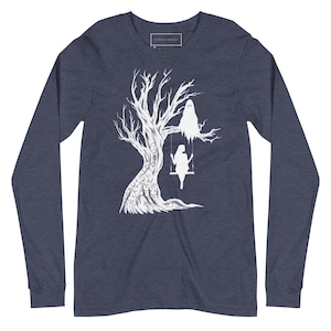 May include: A navy blue long-sleeve t-shirt with a white silhouette of a tree with a ghost and a person on a swing. The tree is covered in words, including "SPELL", "HIDDEN", "SAY", "SHE", "ART", "TO", "GOD", "SO", "FAR", "AND", "YOU".