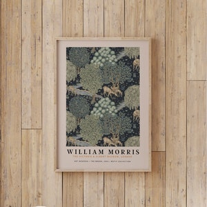 Peut inclure: Une impression encadr&eacute;e d'un motif vintage de William Morris repr&eacute;sentant une sc&egrave;ne de for&ecirc;t avec des arbres, des oiseaux et des cerfs. L'impression est dans un cadre en bois clair et a un fond blanc avec du texte noir.