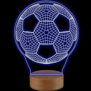 May include: A football-shaped LED lamp with a 3D wireframe design, illuminated in blue. The light sits on a round, wooden base with a power button. The background is black.