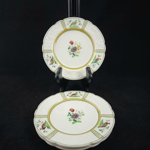 Puede incluir: Juego de tres platos de postre de cerámica blanca con un diseño floral y de pájaros verde, amarillo y rojo.