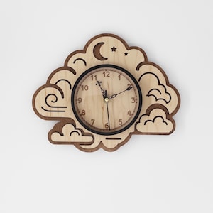 May include: Wooden cloud-shaped wall clock with a light brown face and a dark brown border. The clock features a black clock face with gold hands and numbers. The design includes a crescent moon and star.
