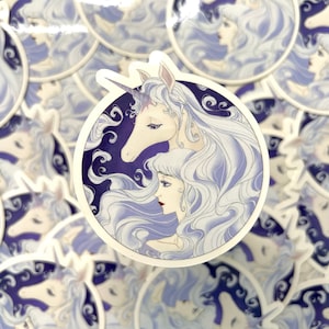 May include: A white unicorn with a purple and white mane and tail is shown with a woman with long white hair. The unicorn and woman are both looking to the left. The image is set against a purple background with white swirls.