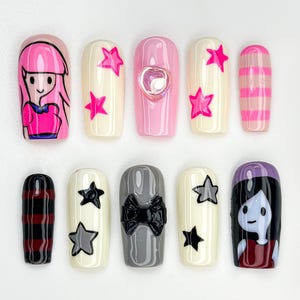 May include: A collection of ten artificial nails with diverse designs. The nails showcase cartoon characters, stars, bows, and striped patterns in pink, white, black, and grey. Some nails have a glossy finish, while others have a matte appearance.