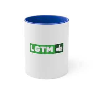 Può includere: Tazza in ceramica bianca con bordo blu e un logo verde e bianco che dice "LGTM" con un'icona di pollice in su.