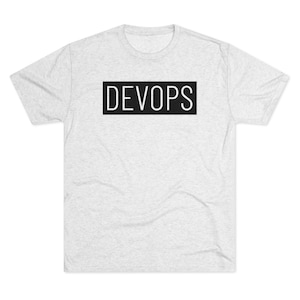 Peut inclure: Un t-shirt gris chiné avec un rectangle noir qui dit "DEVOPS" en texte blanc.