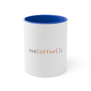 Puede incluir: Taza de cerámica blanca con borde azul y el texto "useCoffee();" en naranja y azul.