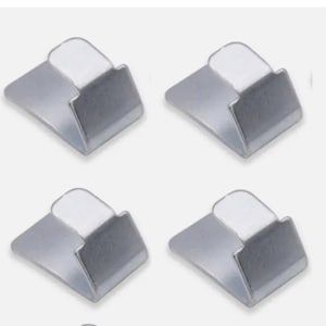 May include: Four silver-colored metal hooks with adhesive backing. The hooks are designed to hold light items like keys, jewelry, or small decorations.