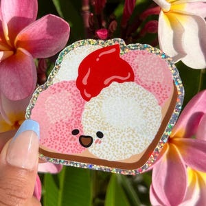 Peut inclure: Un sandwich de dessin anim&eacute; rose, blanc et rouge avec un visage heureux. Le sandwich a une bordure scintillante.
