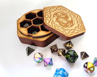 May include: A wooden box with a hexagonal lid, featuring a Celtic knot design and a dragon graphic. The box is open, revealing six compartments for dice.  The box is surrounded by a variety of colorful metal dice.