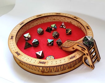 May include: A wooden dice rolling tray with a red felt lining and a slide and ladder for dice. The tray has a decorative border and is filled with various colored dice.