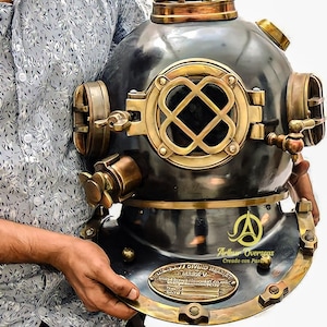 May include: A vintage brass diving helmet with a black finish and a brass viewport. The helmet has a brass nameplate that reads "Le Maiev" and "Diving Helmet".