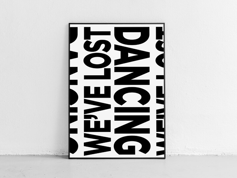 May include: A black and white framed poster with the words 'WE'VE LOST OUR DANCING SHOES' repeated in a vertical pattern.