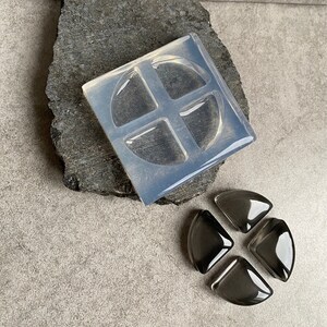 May include: A clear silicone mold with four quarter-circle shapes. Four black resin pieces are shown next to the mold.