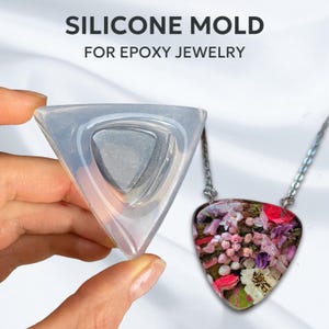 May include: A clear silicone mould shaped like a triangle, used for making jewellery. A finished pendant with dried flowers inside is shown next to the mould.