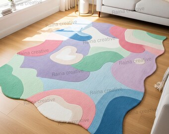 May include: A colorful, abstract area rug with a wavy, organic shape. The rug features a palette of pastel colors, including pink, blue, green, and purple, creating a soft and inviting aesthetic. The rug is placed on a hardwood floor.