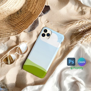 Puede incluir: Una funda de teléfono azul y verde con un diseño de nube blanca. La funda está sobre una superficie arenosa con un sombrero de paja y gafas de sol cerca. El texto "Ps Canva Printify" es visible en la esquina inferior derecha de la imagen.