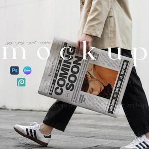 Op de afbeelding: Een persoon loopt over een straat in de stad en houdt een krant vast met de kop "Komt binnenkort" en de tekst "Start in december 2024".