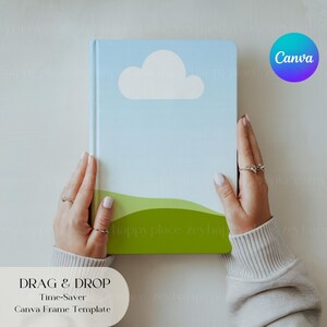 May include: A blue and green notebook with a white cloud and a green hill design. The notebook is being held by two hands. The text "DRAG & DROP Time-Saver Canva Frame Template" is at the bottom of the image.