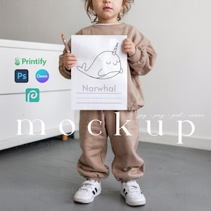 Può includere: Un bambino tiene in mano un foglio di carta bianco con un disegno in bianco e nero di un narvalo. Il disegno è etichettato "Narvalo".