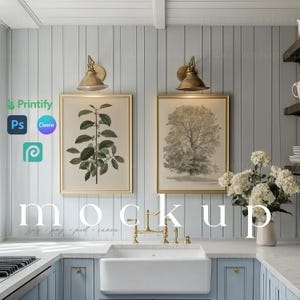 May include: A kitchen interior mockup featuring two framed botanical prints, one depicting a green plant and the other a gray tree. The prints are hung on a light blue wall with white wainscoting. A white farmhouse sink with a gold tap is in the foreground. The countertop is white marble.