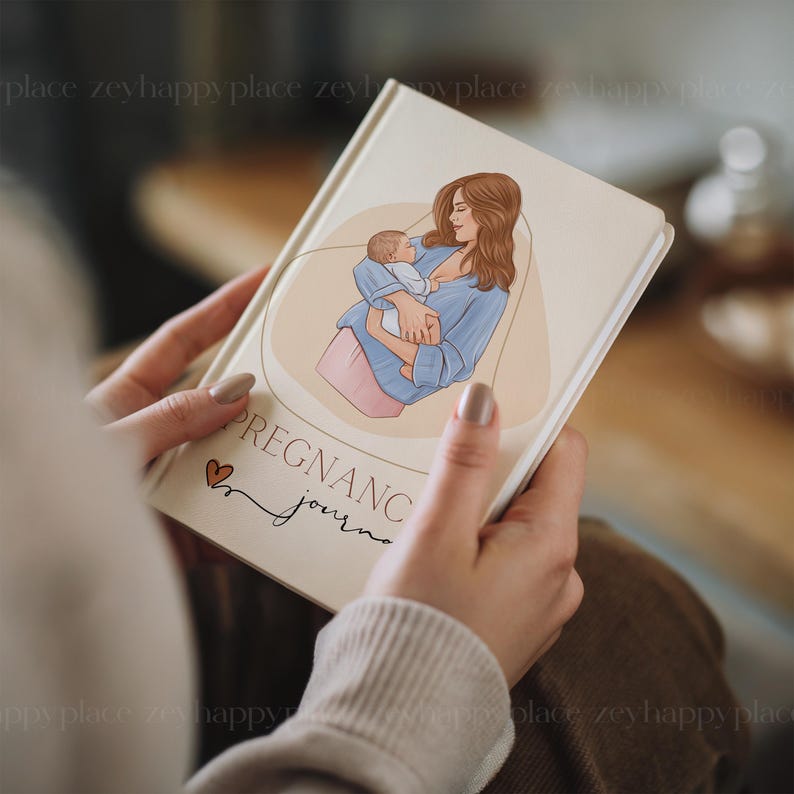May include: A white journal with a brown heart and the text "Pregnancy Journal" on the cover. The cover features an illustration of a woman holding a baby.