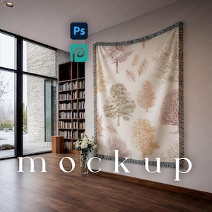 May include: A cream-colored woven throw blanket with a tree and leaf pattern in shades of brown, gold, and green hangs on a wall. The word "mockup" is displayed in white text on the floor. A bookshelf and large window are visible.