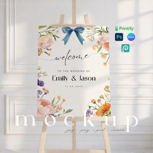 Könnte beinhalten: Ein Mockup eines Hochzeitsschildes mit Blumenmuster. Das Schild steht auf einem Staffelei und trägt den Text "welcome" und "to the wedding of Emily & Jason 11.06.2025".