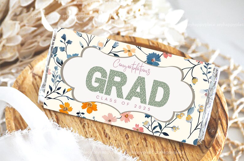 May include: A white chocolate bar wrapper featuring a floral design in shades of blue, yellow, and pink. The text "Congratulations Grad Class of 2025" is printed on the wrapper.