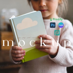 May include: A child is holding a blue and green notebook with a white cloud design. The notebook has the text "jpg - png - psd - canva" printed on the cover. The text "mockup" is printed in white on a black background below the notebook.