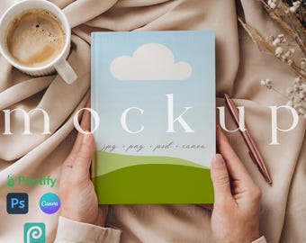 Può includere: Un mockup di una copertina di libro con un cielo blu, una nuvola bianca e un design di collina verde. Il testo "jpg, png, psd, canva" è stampato sulla copertina.