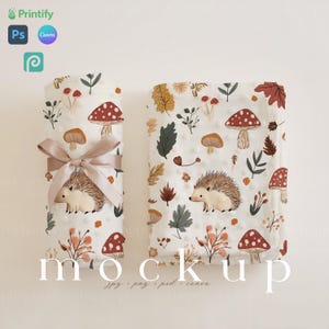 Puede incluir: Dos mantas de bebé de tela blanca con un patrón de erizo, hongo y hojas. Las mantas están sobre una superficie blanca. Maqueta.