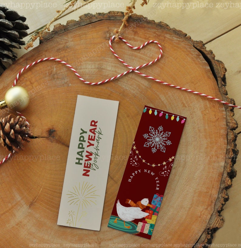Puede incluir: Dos marcap&aacute;ginas con tem&aacute;tica de A&ntilde;o Nuevo. Un marcap&aacute;ginas es beige con fuegos artificiales dorados y el texto "Happy New Year Bookmark". El otro marcap&aacute;ginas es rojo con un copo de nieve blanco, un ganso blanco con una bufanda y el texto "Happy New Year".