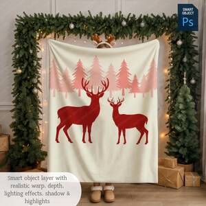 May include: A cream-colored blanket featuring a red deer silhouette design with a forest of pink trees. The blanket is draped, with the text "Smart object layer with realistic warp, depth, lighting effects, shadow & highlights" at the bottom.